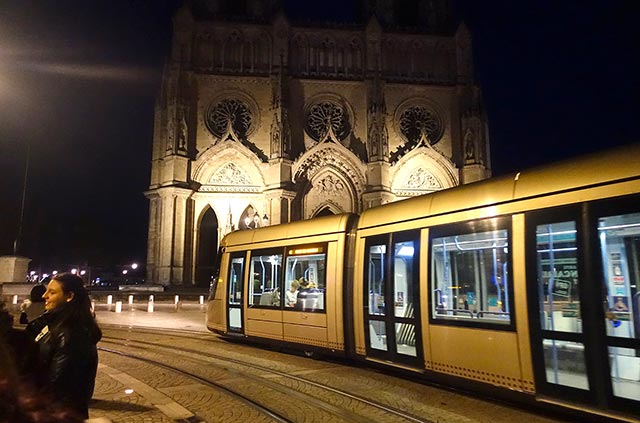 Rumeni tramvaj pred nočno podobo katedrale