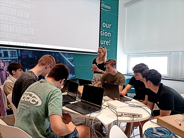 Dijaki sedijo za prenosniki in programirajo.