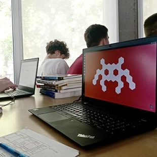 Na fotografiji je videti zaslon prenosnika, ki prikazuje logotip Računalniškega muzeja.