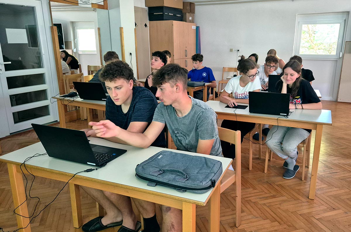 Dijaki v učilnici za prenosniki
