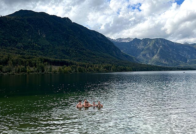 Pet dijakov in dijakinj plava v Bohinjskem jezeru, ki je konec septembra že hladno.