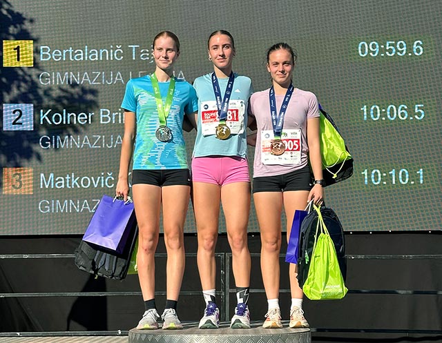 Na najvišji stpnički za podelitev nagrad stojijo tri dijakinje, okrog vratu imajo medalje za prvo, drugo in tretje mesto.