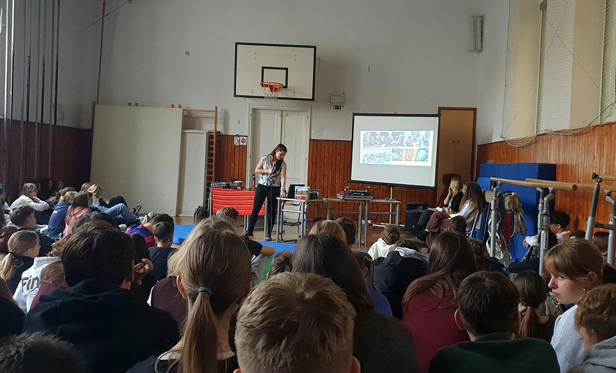 Jana Dular Wang'ombe predava dijakom v mali telovadnici šole.