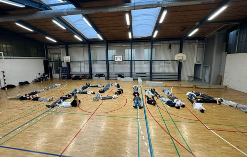 V šolski telovadnici so dijaki s telesi oblikovali ime gostujoče šole.