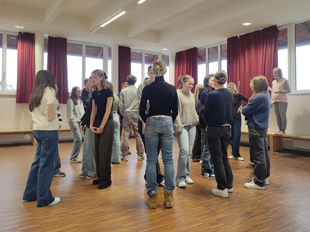 Spoznavanje med udeleženci izmenjave: dijaki stojijo v krogu in se pogovarjajo v parih.