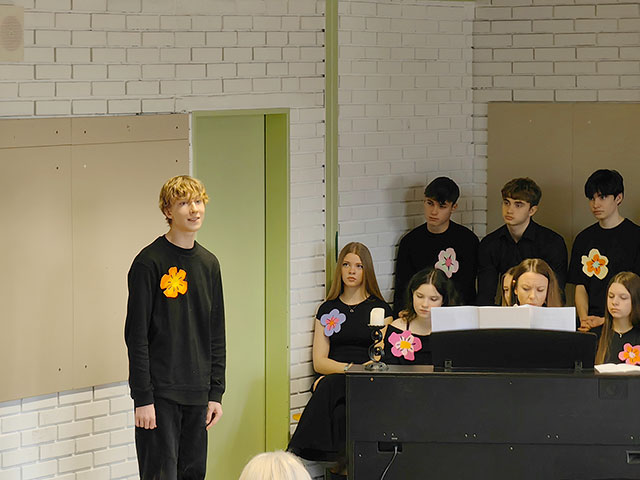 Dijak nastopa s solo pevsko točko. na klavirju ga spremlja profesorica glasbe.