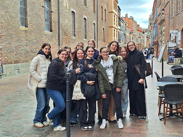 Manjša skupina dijakov na ulicah Toulousa. So dobro razpoloženi, smejijo se.