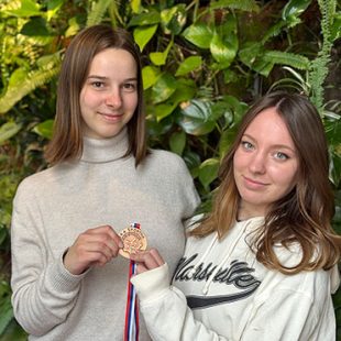 Dijakinji držita v rokah bronasto medaljo s tekmovanja v namiznem tenisu.