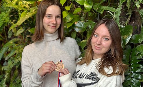Dijakinji držita v rokah bronasto medaljo s tekmovanja v namiznem tenisu.
