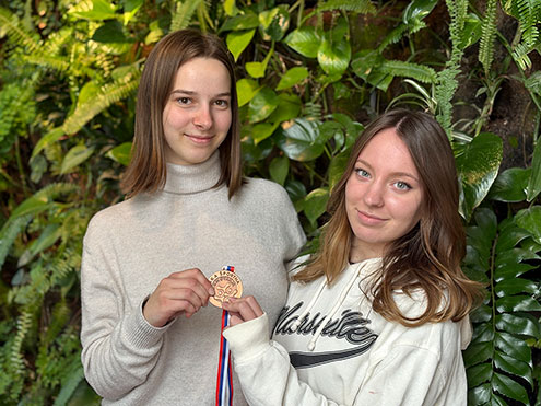 Dijakinji držita v rokah bronasto medaljo s tekmovanja v namiznem tenisu.