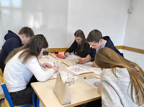 Tri dijakinje in dva dijaka sedijo za mizo in so zatopljeni v reševanje sudoka.