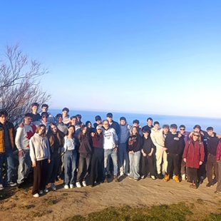 Na fotografiji je skupina približno 50 slovenskih in italijanskih dijakov, ki pozirajo za spominsko fotografijo na prostem. Stojijo na razgledni točki s pogledom na morje in nebom brez oblačka v ozadju. Oblečeni so v vsakdanja oblačila, kot so jakne, puloverji in hlače.