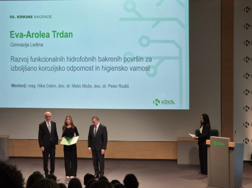 Eva-Arolea Trdan v rokah drži Krkino nagrado, ob njej sta podeljevalca nagrade.